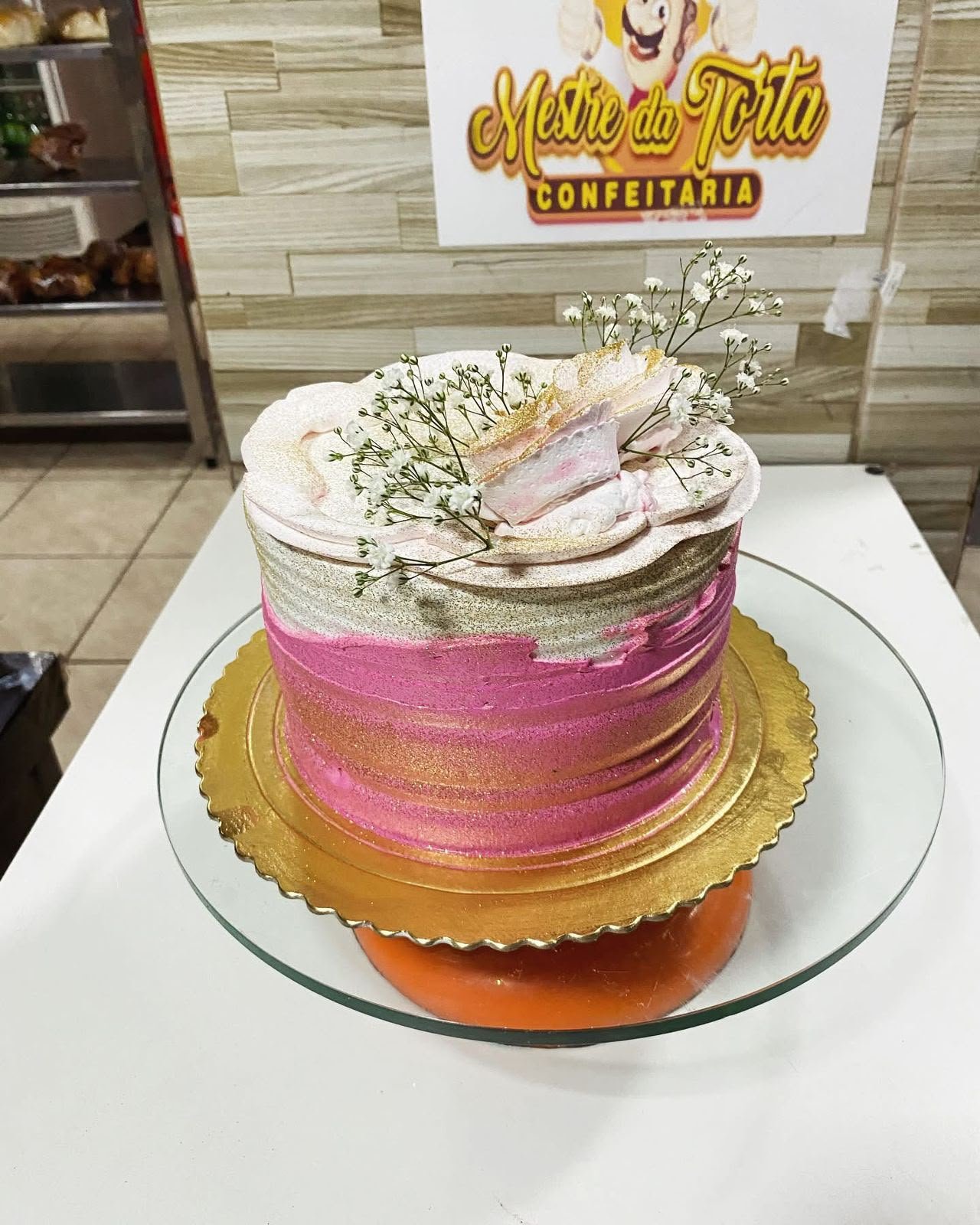 Bolo rosa e dourado com flores de gipsofila